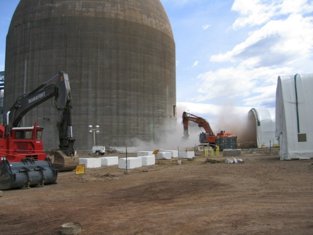 The containment building being lowered by collapsing sections of the bottom
